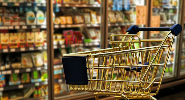Einkaufswagen vor einem Regal im Supermarkt